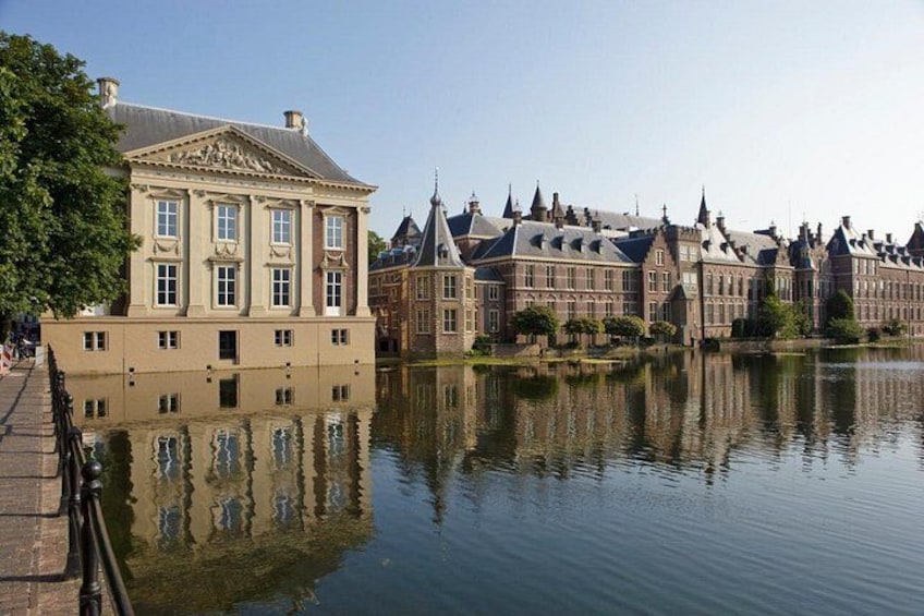 A canal with a historic building reflecting on the water. 1