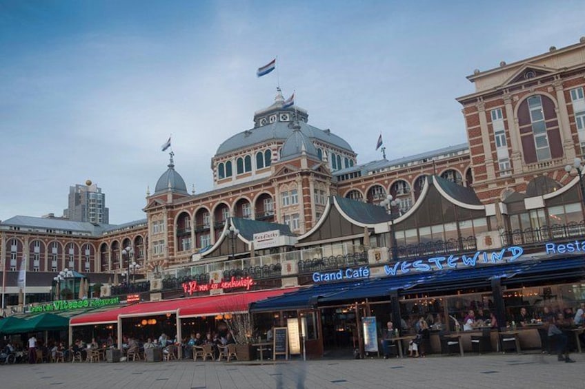 A historic building with a dome and arched windows, surrounded by cafes and restaurants. 2
