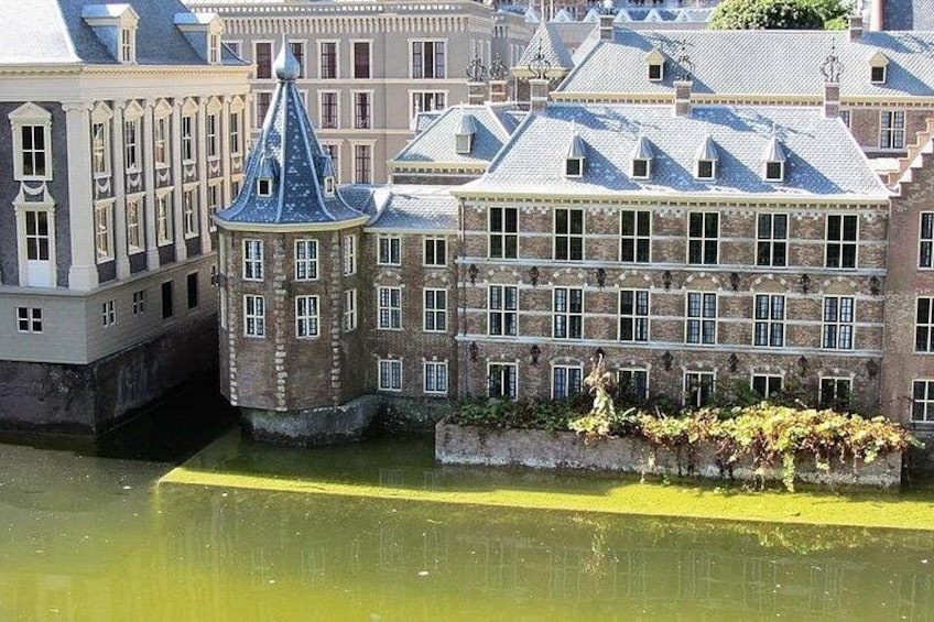 A historic building with a tower and a canal in the foreground. 3