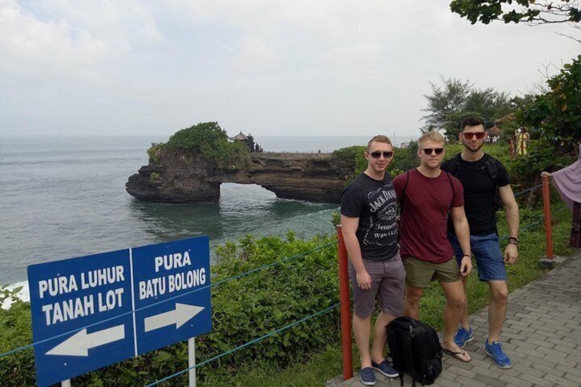 A coastal landmark with directional signs for Pura Luhur and Pura Batu Bolong. 4
