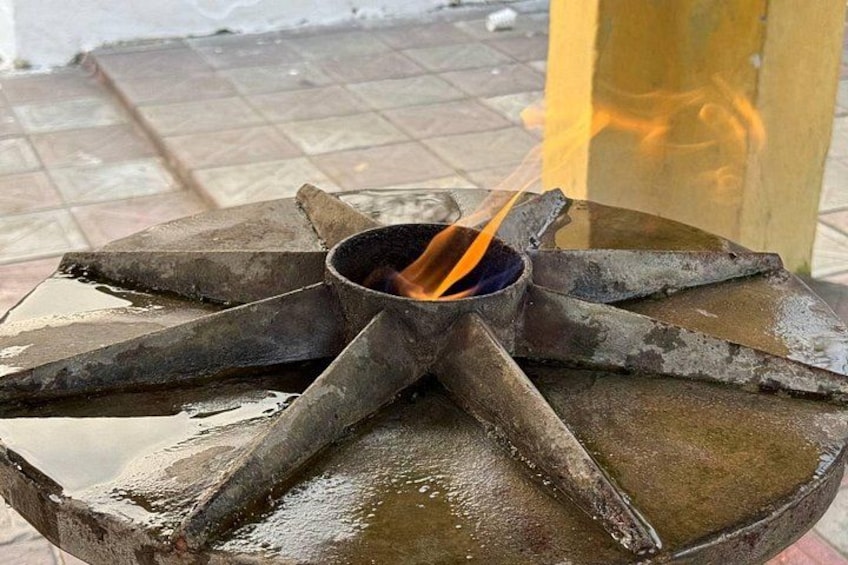 A metal fire pit with a burning flame. 4