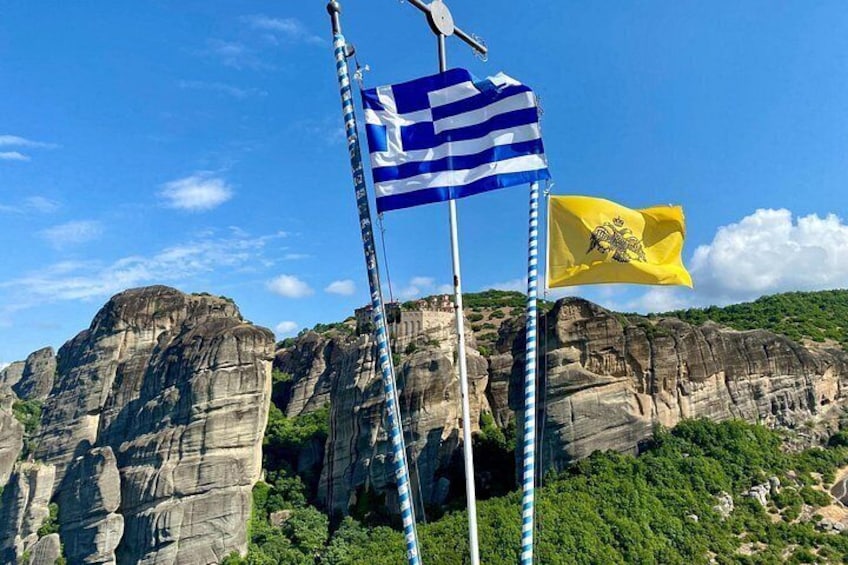Two flags on flagpoles, a rocky landscape, and a clear blue sky. 5