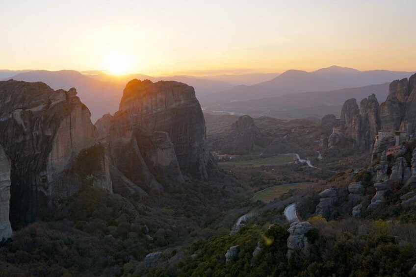 A mountainous landscape with rock formations during sunset. 2