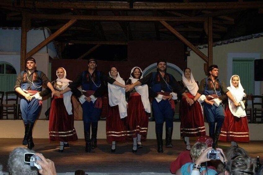 Un grupo de personas vestidas con trajes tradicionales actuando en un escenario. 1