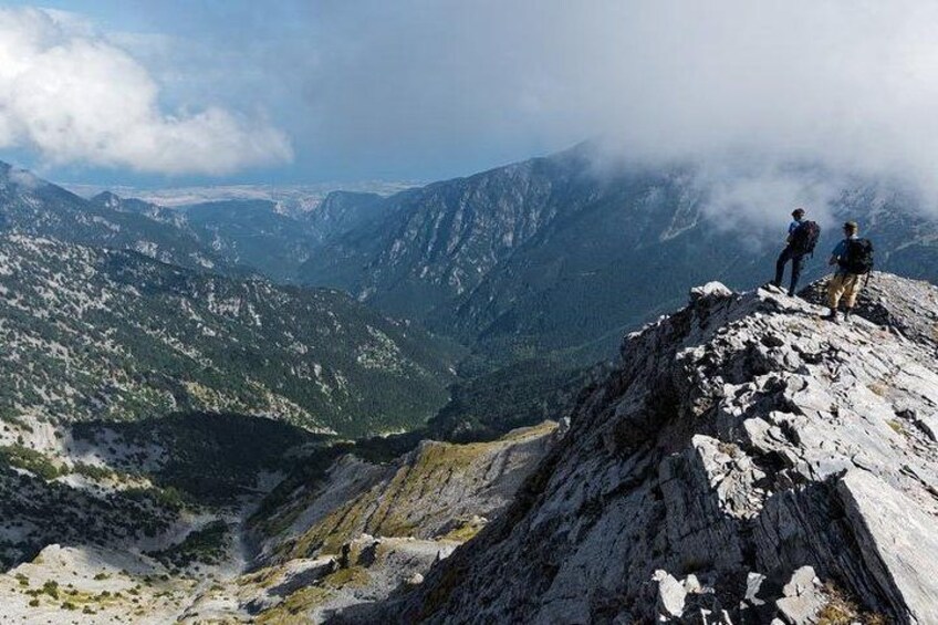 A mountainous landscape with hikers on a ridge. 3