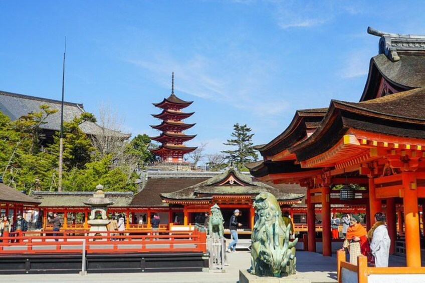 Un templo japonés tradicional con una pagoda, torii rojos y una estatua de piedra. 2
