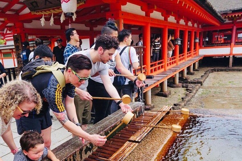 Personas sirviendo salsa de soya a pescado a la parrilla en un ambiente tradicional japonés. 1