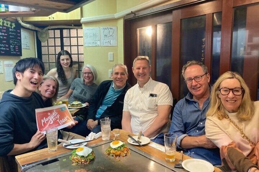 A group of people sitting around a table with food and drinks. 5