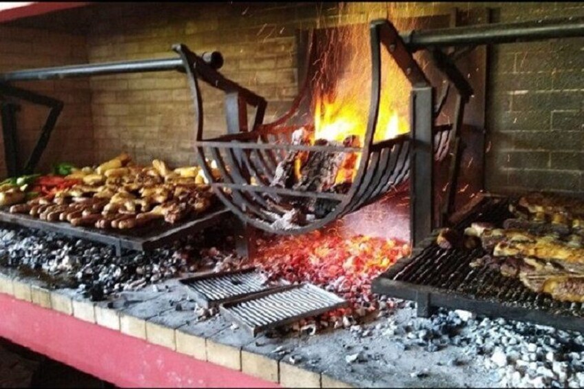 Una griglia da barbecue con diversi tipi di carne che cuoce su fiamma viva. 2