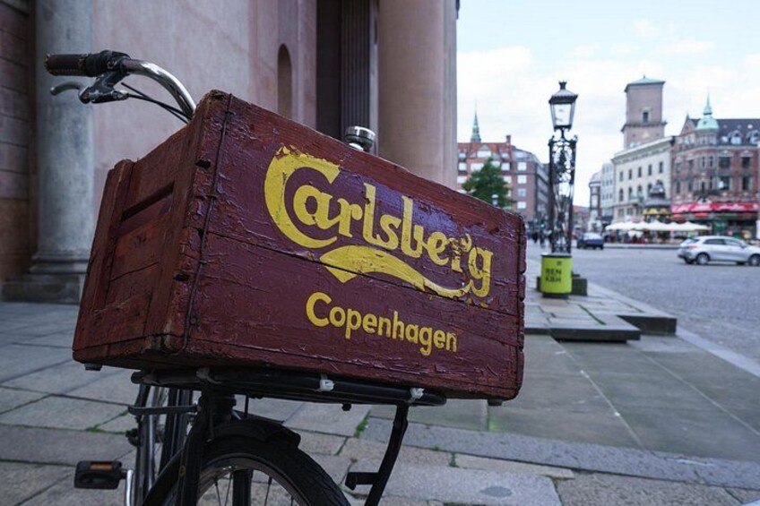 A wooden box with 'Carlsberg Copenhagen' written on it, attached to a bicycle. 4