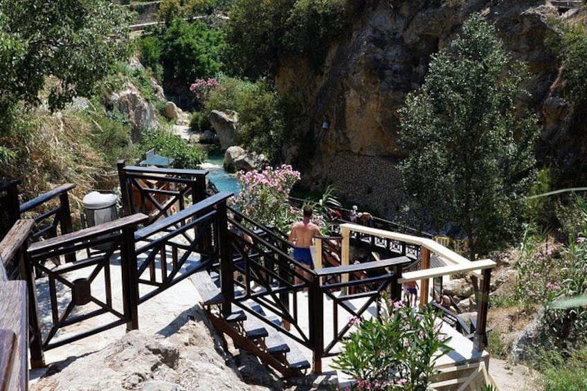 A wooden deck with benches overlooking a rocky canyon with a river. 3