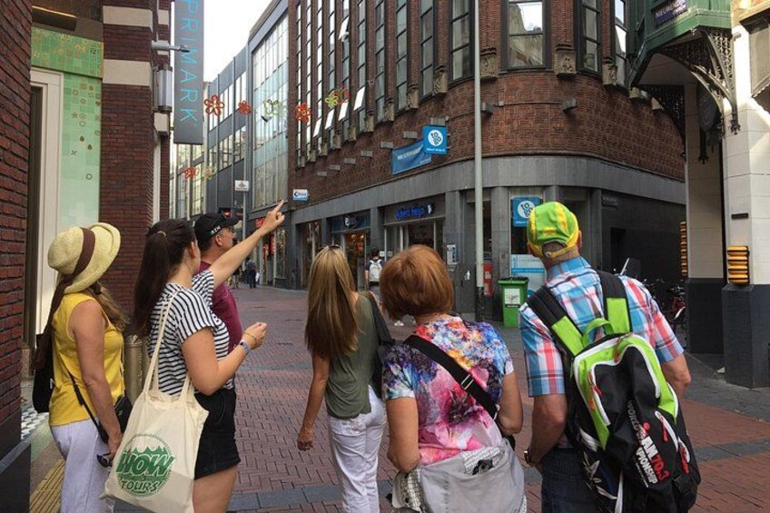 Un grupo de personas caminando por una calle de la ciudad, con edificios y un letrero que dice 'PRIMARK'. 4