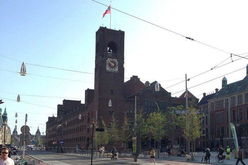 Un edificio histórico con una torre de reloj, rodeado de árboles y otros edificios. 3