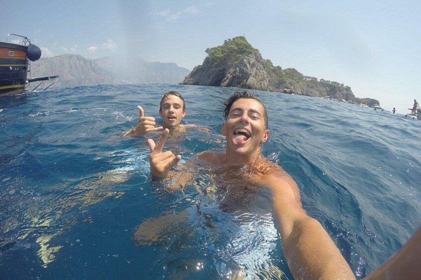 Due persone in piscina con una barca e un paesaggio roccioso sullo sfondo. 2