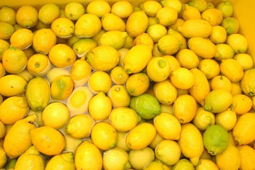 A large quantity of lemons in a container. 2