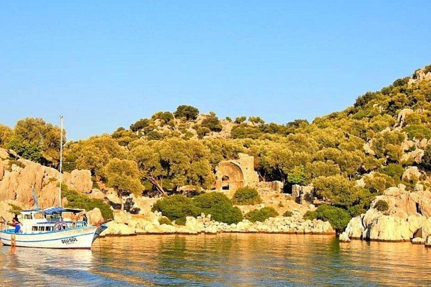 A boat on calm water, rocky terrain, and a small building on a hill. 2