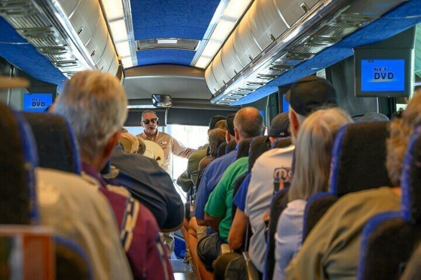 Passengers seated in a train cabin with overhead luggage racks and a screen displaying 'DVD'. 5