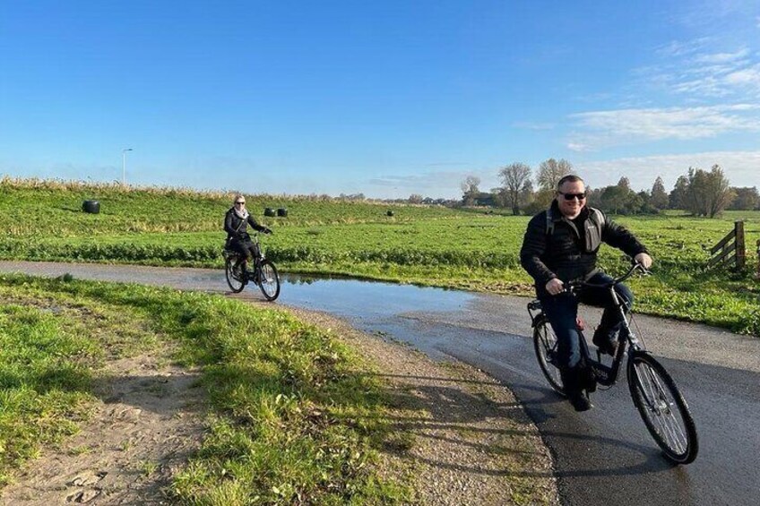 Dos ciclistas en un camino rural junto a un pequeño arroyo. 3