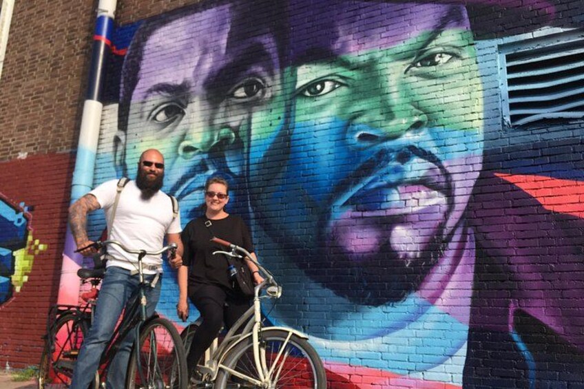 Un mural con una persona y una bicicleta frente a él. 2