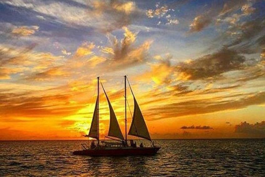 A sailboat on calm waters during sunset with a colorful sky. 1