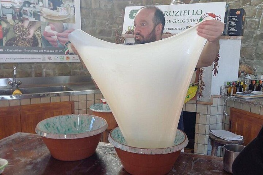 A person holding a large, white, cone-shaped object over two bowls. 4