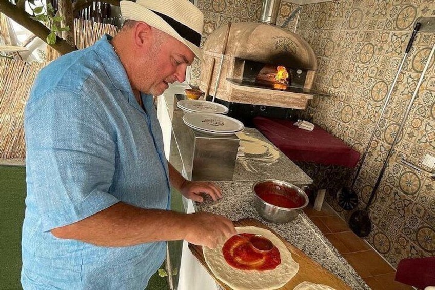 A man preparing food in a kitchen with a wood-fired oven. 2