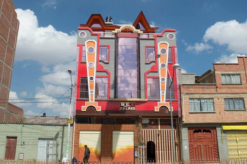 A colorful building with a unique architectural design, featuring a large window and a sign that reads 'RE PALECE'. 4