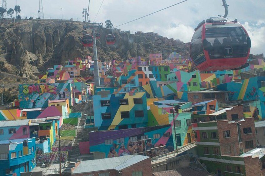 A colorful hillside settlement with a cable car. 5