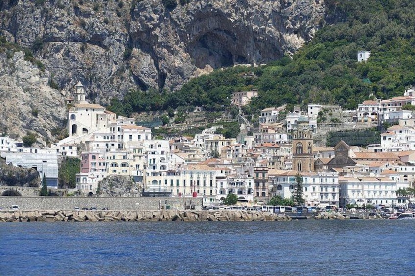 A coastal town with buildings, a church, and rocky cliffs. 2