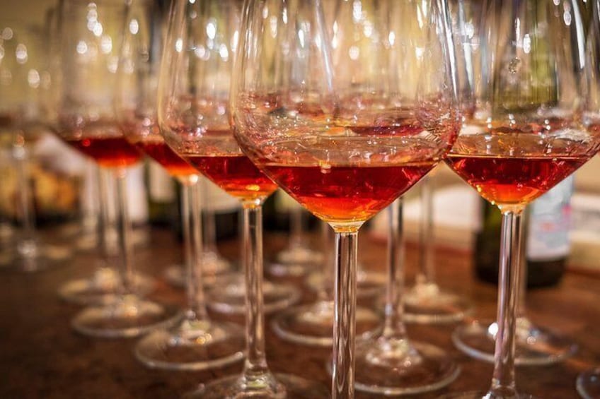Une rangée de verres à vin remplis de vin rouge est posée sur le comptoir d’un bar. 5
