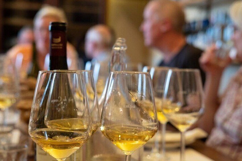 Des verres à vin remplis de vin blanc, une bouteille de vin et un verre à vin doté d’un pied. 4