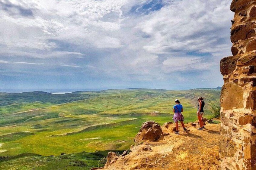 Two people standing on a rocky outcrop overlooking a valley. 1