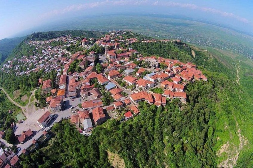 A town nestled in a valley surrounded by forested hills. 3