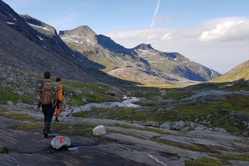 Een bergachtig landschap met wandelaars op een rotsachtig pad. 2
