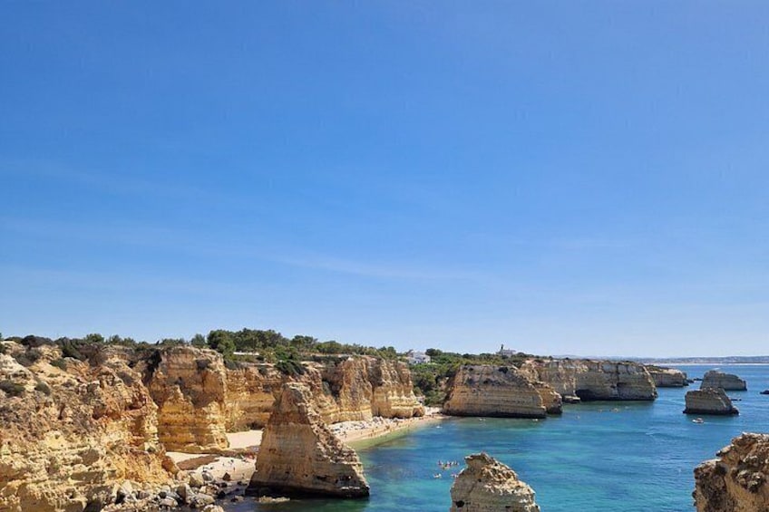 A coastal landscape with rocky cliffs and clear blue water. 2
