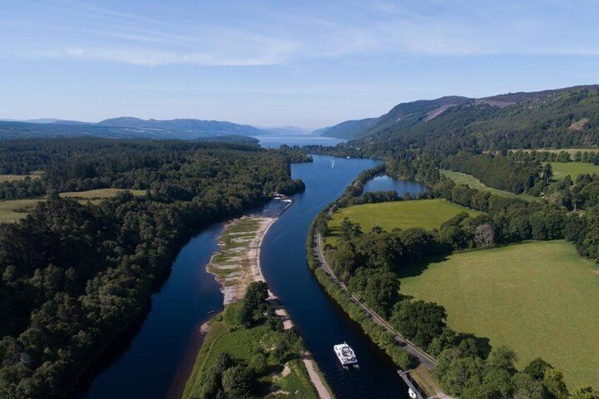 A river winding through a green landscape with hills in the background. 2