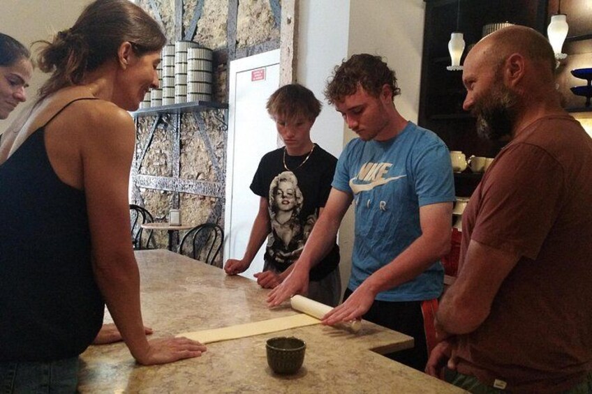 Un grupo de personas en una cocina, amasando masa sobre una encimera. 1