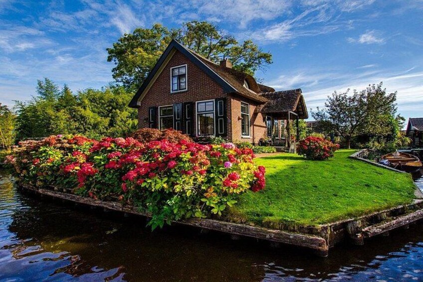 Une maison construite sur une plateforme flottante, dotée de jardins luxuriants et bordée d’un canal. 1