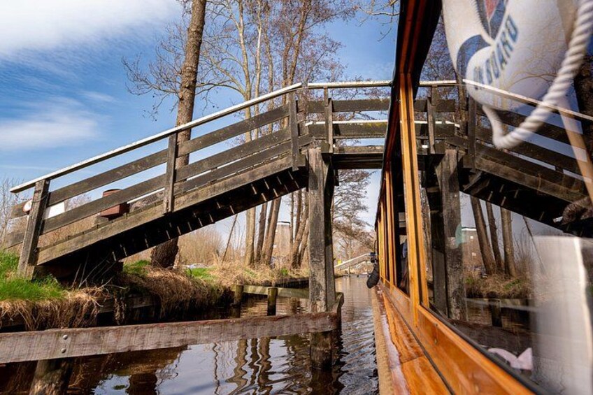 Un pont en bois enjambant une étendue d’eau, avec des arbres en arrière-plan. 2