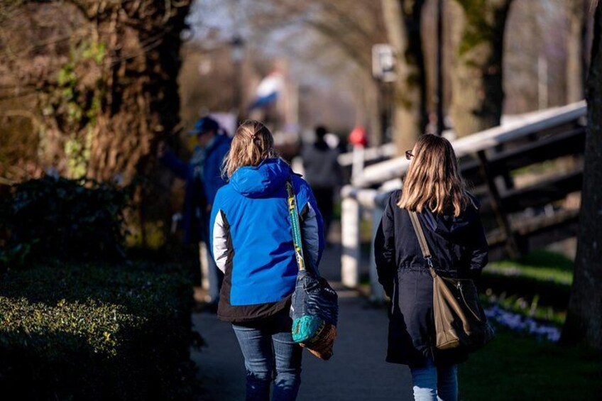 Deux personnes se promènent sur un sentier dans un parc, bordé d’arbres et délimité par une clôture en bois. 4
