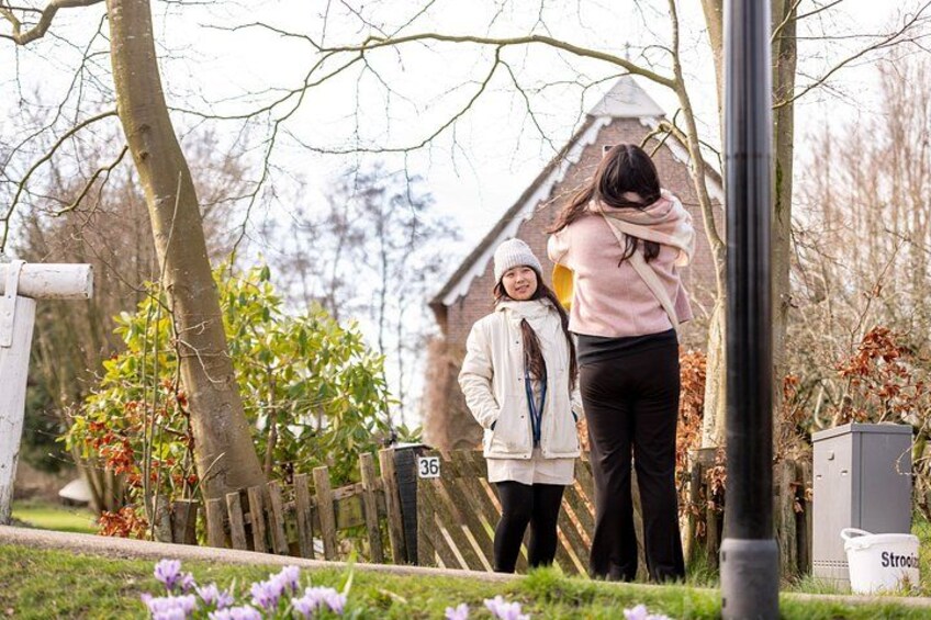Une femme et un enfant se tiennent devant un bâtiment sur lequel on peut voir un numéro, entourés d’arbres et d’une clôture. 3