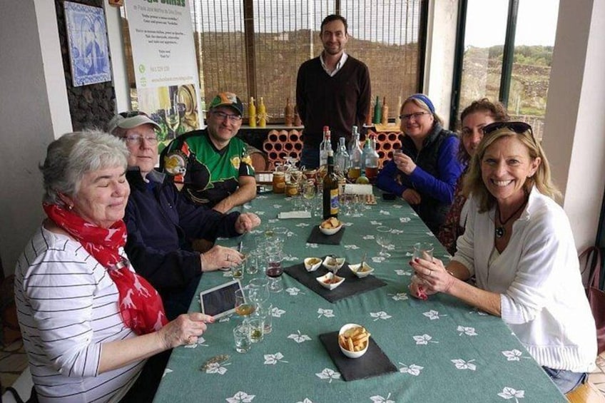 A group of people seated around a table with wine glasses and bottles, in a room with a view outside. 3