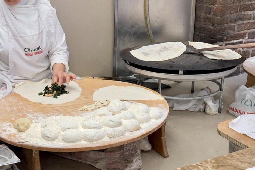 A person preparing food, with dough and ingredients on a table. 5