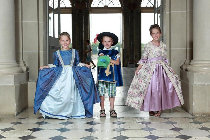 Three people in historical costumes standing in a doorway with a tiled floor. 2