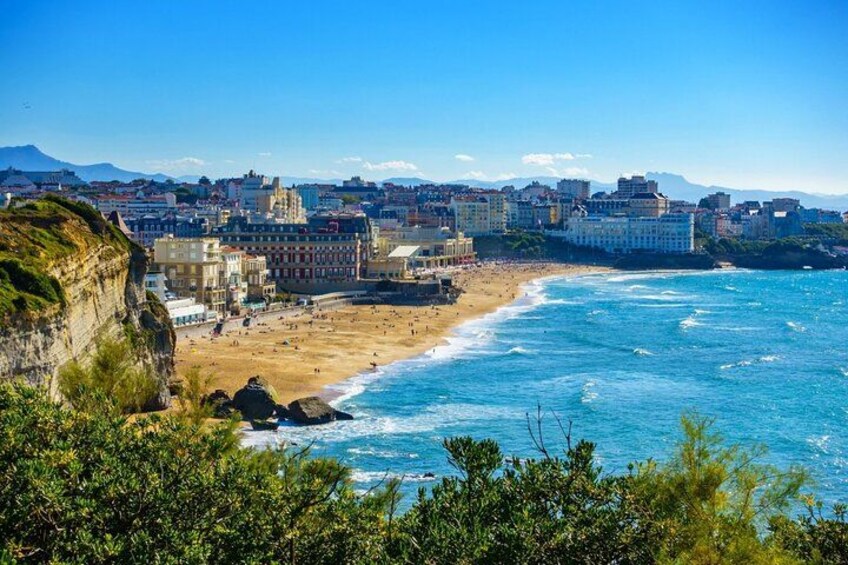 Un paysage urbain côtier avec une plage, des falaises et des bâtiments. 1