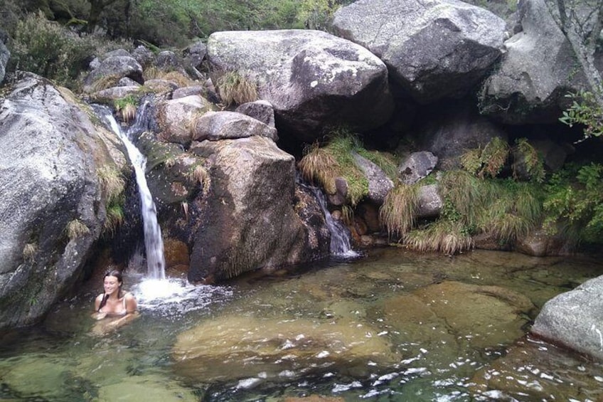 A waterfall, rocks, and a person in a natural setting. 4
