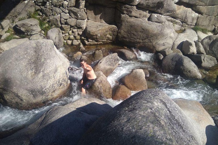 Une personne se tient sur des rochers, au bord d’une rivière. 4