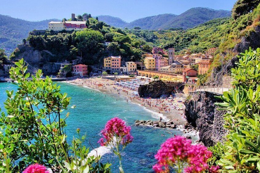 A coastal town with colorful buildings, a beach, and a cliff overlooking the sea. 2