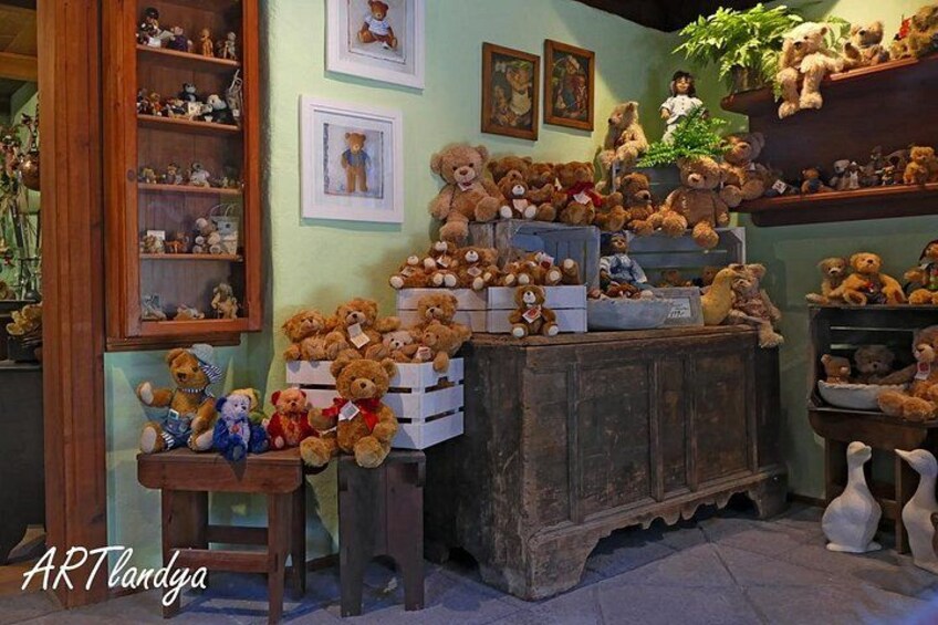 Une pièce remplie de nounours, d’étagères en bois et de tableaux encadrés. 2