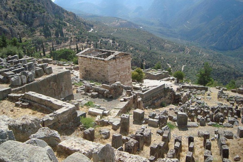 Ancient ruins with stone blocks and walls, set against a mountainous backdrop. 2